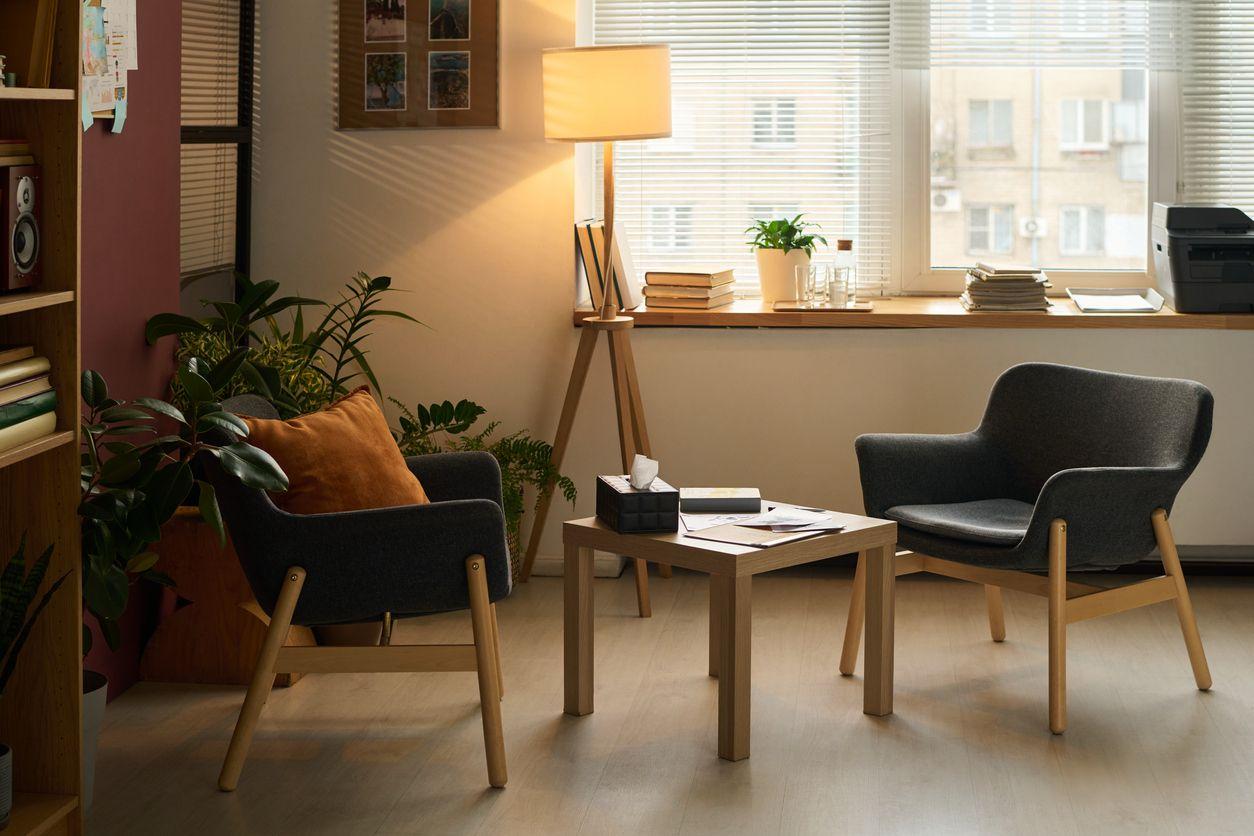 Espacio de consulta cálido con sillones y luz natural